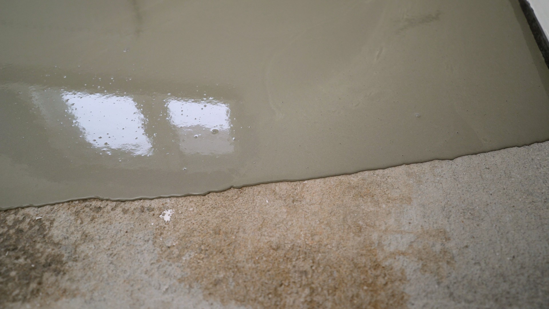 Workers applying epoxy resin flooring in commercial or industrial space